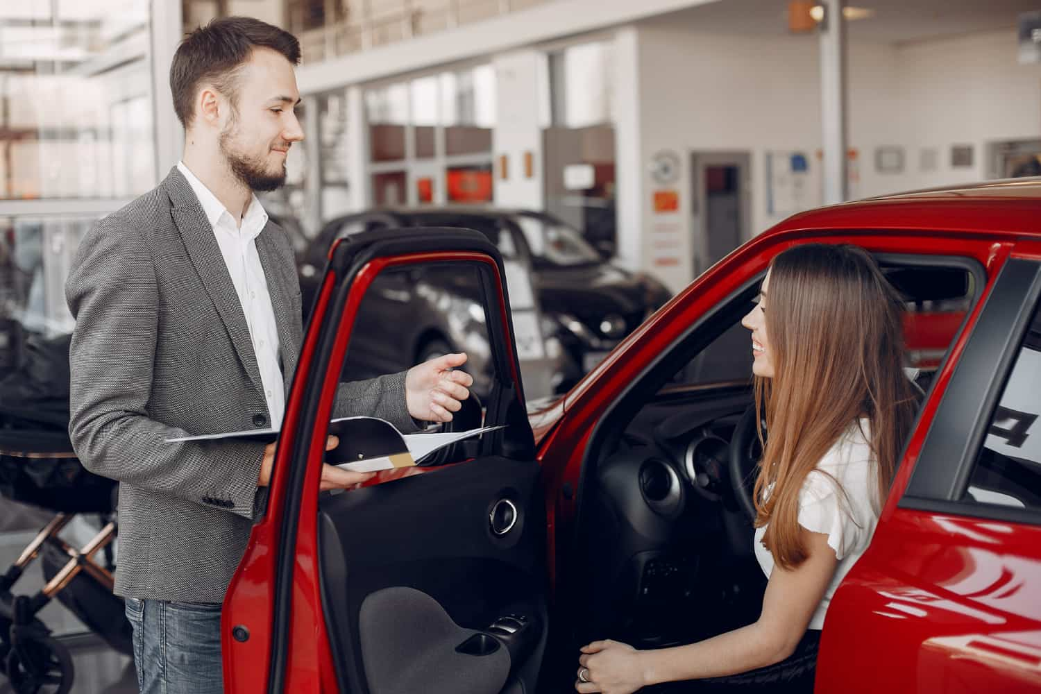 Mujer siendo asesorada sobre la compra de un coche de ocasión.